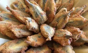 Un piatto invitante di acciughe ripiene alla ligure, dorate e croccanti, pronte per essere gustate.