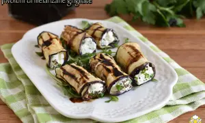 Involtini di melanzane grigliate ripieni di formaggio fresco e erbe aromatiche, conditi con glassa balsamica.