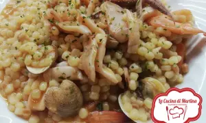 Pasta di semola con frutti di mare, cozze, gamberi e polpo, guarnita con prezzemolo.