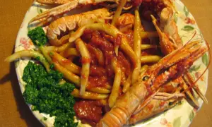 Gnocchi alla busara con scampi e un contorno di verdure verdi. Un piatto invitante e saporito.