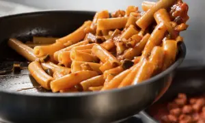 Rigatoni conditi con un sugo ricco e saporito, pronti per essere serviti. Un classico piatto di pasta al pomodoro che fa venire l'acquolina in bocca.