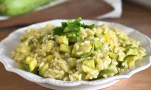 Un cremoso risotto con zucchine, guarnito con prezzemolo fresco, pronto per essere gustato.