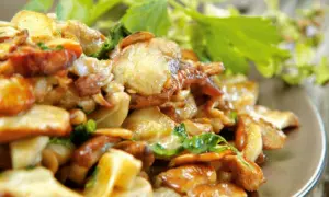 Un piatto invitante di funghi trifolati, dorati e profumati, guarniti con erbe fresche.