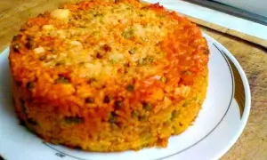Timballo di riso dorato e invitante, con piselli e una crosticina croccante, pronto per essere gustato.