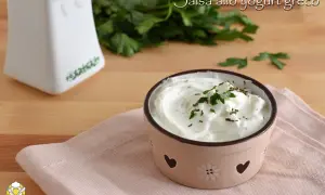 Salsa allo yogurt greco cremosa, guarnita con prezzemolo fresco, perfetta per insalate leggere e gustose.