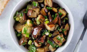 Melanzane viola ricette in padella: cubetti dorati e saporiti, conditi con erbe fresche, pronti per essere gustati.
