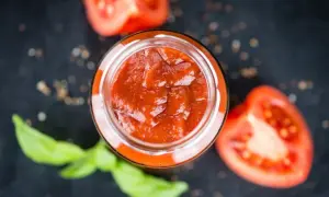 Un vasetto di sugo al pomodoro fatto in casa, con pomodori freschi e basilico, pronto per condire la pasta.