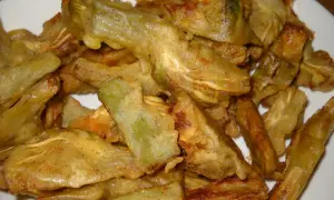 Piatto di carciofi fritti senza pastella, dorati e croccanti, pronti per essere gustati.