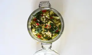 Barattolo di zucchine sott'olio con aglio, peperoncino e erbe aromatiche.
