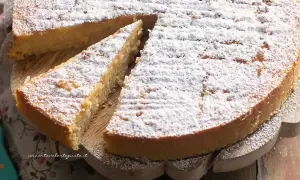 Torta di riso ricetta: una fetta di torta soffice e dorata, cosparsa di zucchero a velo, pronta per essere gustata.