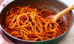 Spaghetti all'assassina ricetta: pasta cotta in padella con sugo rosso piccante, pronta per essere gustata.