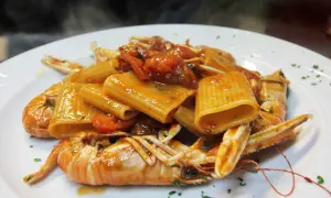 Rigatoni con scampi e pomodorini, un classico dei primi piatti della domenica, fumante e invitante.