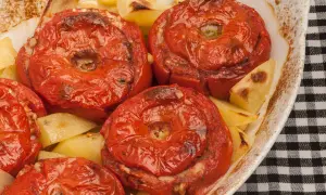 Pomodori ripieni di riso e patate al forno, un piatto saporito e colorato.