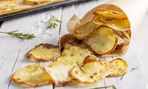 Patate al forno veloci, croccanti e dorate, condite con sale e rosmarino, servite in un cono di carta.