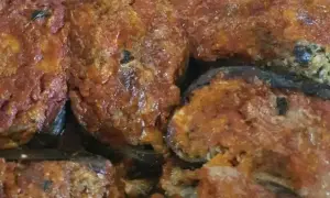 Melanzane ripiene calabresi, un piatto ricco e saporito, con un ripieno gustoso e una salsa rossa invitante.