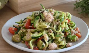 Deliziosa insalata di zucchine a spirale con tonno, pomodorini e olive verdi, un piatto fresco e leggero.
