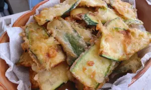 Fette dorate di zucchine in pastella, croccanti e invitanti, pronte per essere gustate.