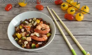 Un piatto di riso rosso con gamberi e verdure, un'idea per ricette veloci e gustose. Mandorle a lamelle completano il tutto.