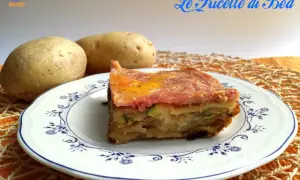 Una fetta di parmigiana di zucchine e patate, con prosciutto e formaggio fuso, servita su un piatto decorato.