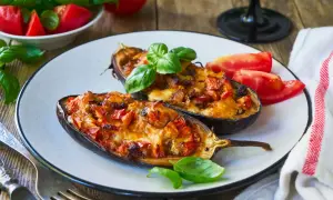 Melanzane ripiene senza carne, dorate e filanti, guarnite con basilico fresco. Un piatto vegetariano invitante.
