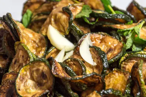 Zucchine alla scapece ricetta: fette di zucchine fritte e marinate con aglio e menta, un contorno saporito e fresco.