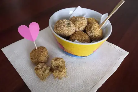 Deliziose polpette di ceci, croccanti fuori e morbide dentro, servite in una ciotola colorata con un cuore rosa.