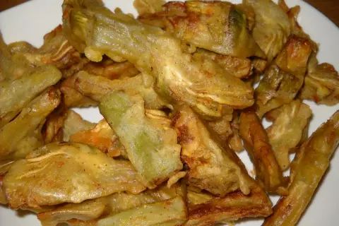 Piatto di carciofi fritti senza pastella, dorati e croccanti, pronti per essere gustati.