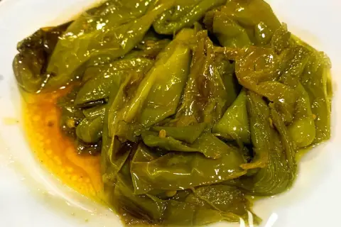 Friggitelli in padella alla napoletana, teneri e succosi, cotti in olio d'oliva e profumati.