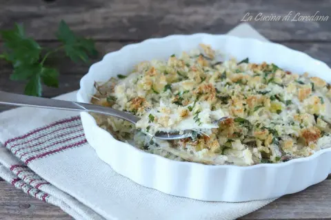 Un invitante tortino di alici gratinato, con croccante pangrattato e prezzemolo fresco, pronto per essere gustato.
