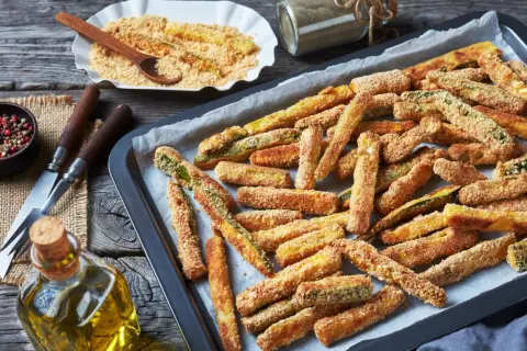 Bastoncini croccanti di zucchine al forno, pronti per essere gustati. Un contorno sfizioso e leggero.