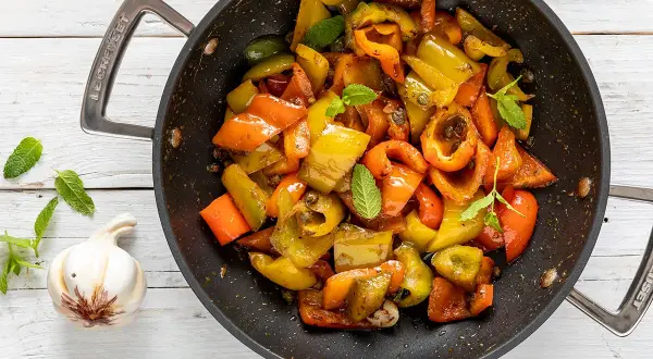 Peperoni in padella, colorati e succosi, cotti con aglio e menta. Un contorno saporito e facile da preparare.
