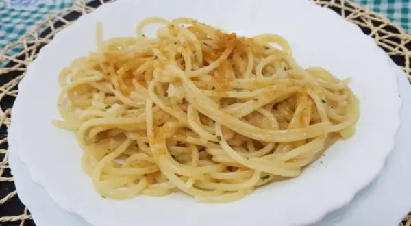 Spaghetti conditi con un filo d'olio, aglio e prezzemolo, spolverati con la preziosa bottarga.