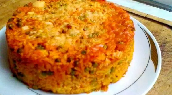 Timballo di riso dorato e invitante, con piselli e una crosticina croccante, pronto per essere gustato.