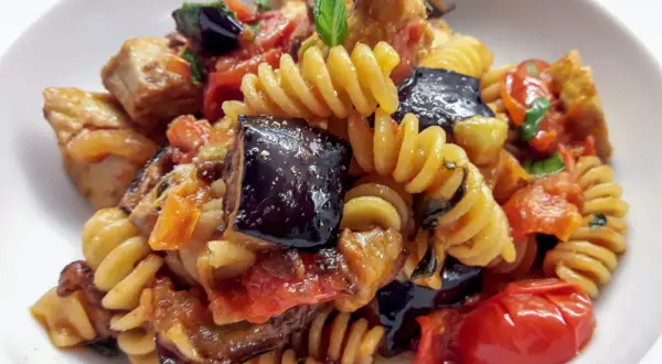 Fusilli con pesce spada, melanzane, pomodorini e basilico, un piatto estivo saporito e colorato.