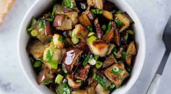 Melanzane viola ricette in padella: cubetti dorati e saporiti, conditi con erbe fresche, pronti per essere gustati.