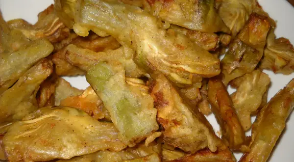 Piatto di carciofi fritti senza pastella, dorati e croccanti, pronti per essere gustati.