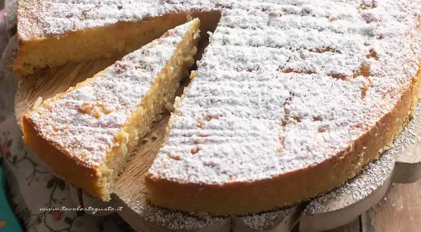 Torta di riso ricetta: una fetta di torta soffice e dorata, cosparsa di zucchero a velo, pronta per essere gustata.