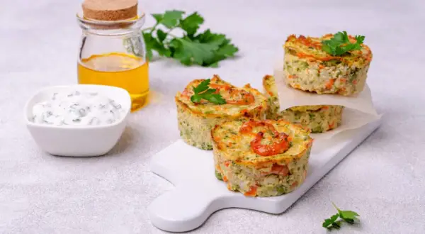 Deliziosi tortini di zucchine con gamberetti, serviti con salsa e olio.