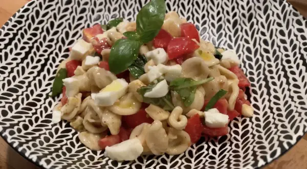 Orecchiette con pomodorini freschi, mozzarella, basilico e un filo d'olio. Un piatto estivo perfetto: pasta alla crudaiola.