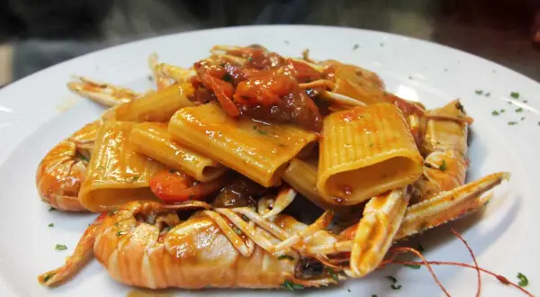 Rigatoni con scampi e pomodorini, un classico dei primi piatti della domenica, fumante e invitante.