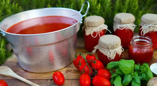 Salsa di pomodoro fatta in casa da conservare, con pomodori freschi e basilico. Un tesoro rosso in barattoli pronti per l'inverno.