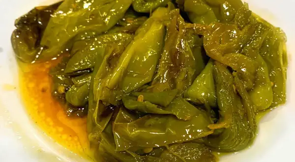 Friggitelli in padella alla napoletana, teneri e succosi, cotti in olio d'oliva e profumati.