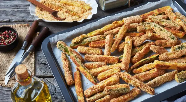Bastoncini croccanti di zucchine al forno, pronti per essere gustati. Un contorno sfizioso e leggero.