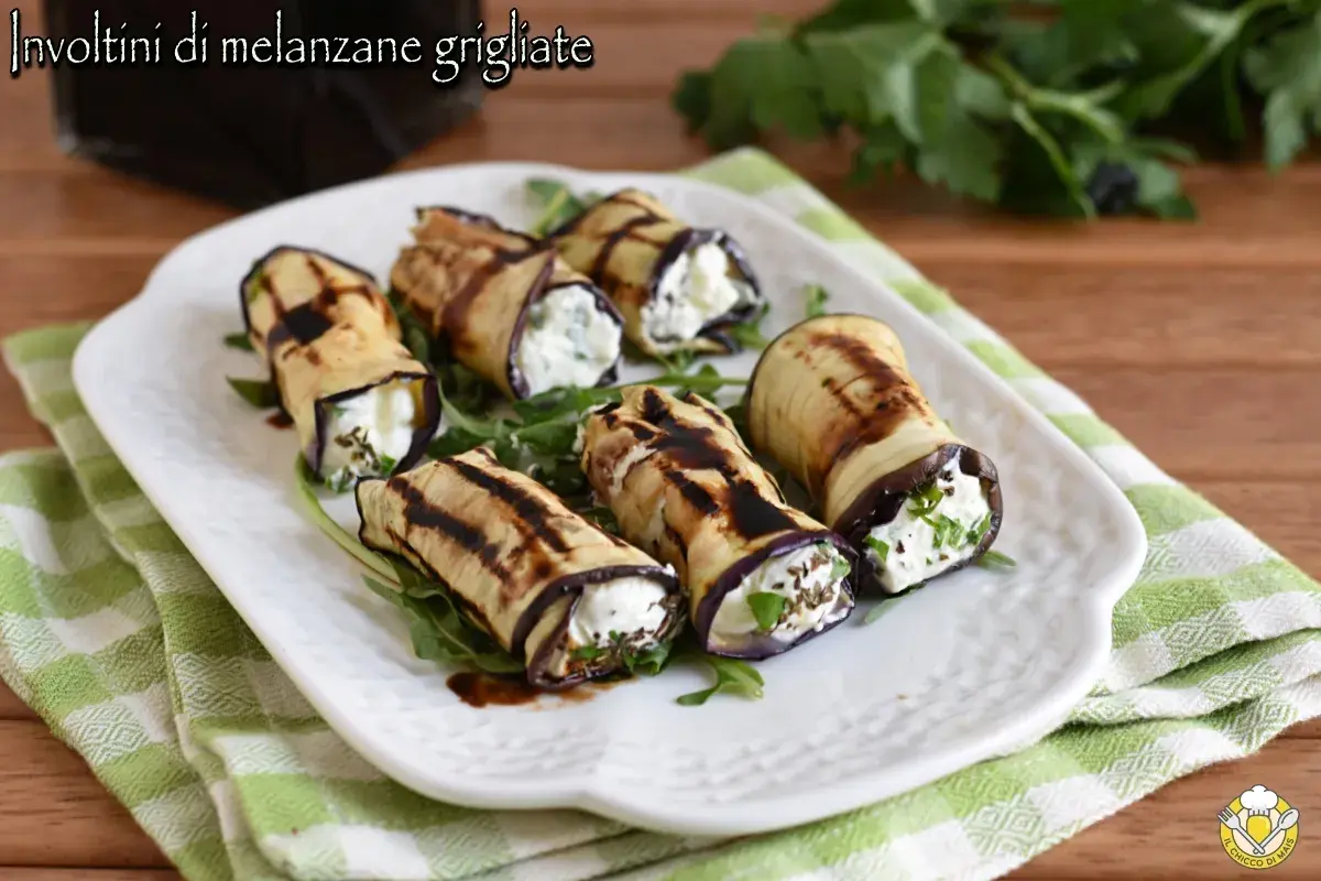 Involtini di melanzane grigliate ripieni di formaggio fresco e erbe aromatiche, conditi con glassa balsamica.