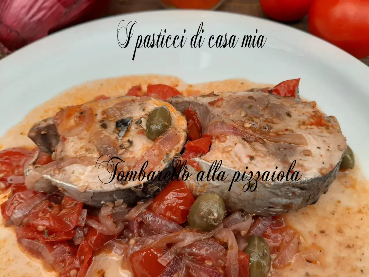 Tranci di tombarello alla pizzaiola, un classico tra le ricette di pesce, serviti con pomodoro, olive e cipolla.