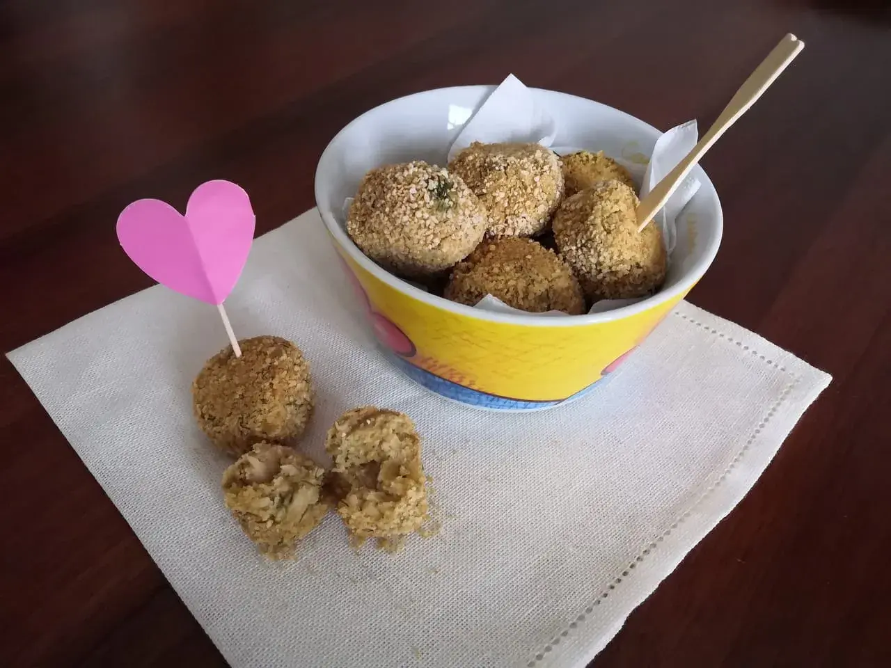 Deliziose polpette di ceci, croccanti fuori e morbide dentro, servite in una ciotola colorata con un cuore rosa.