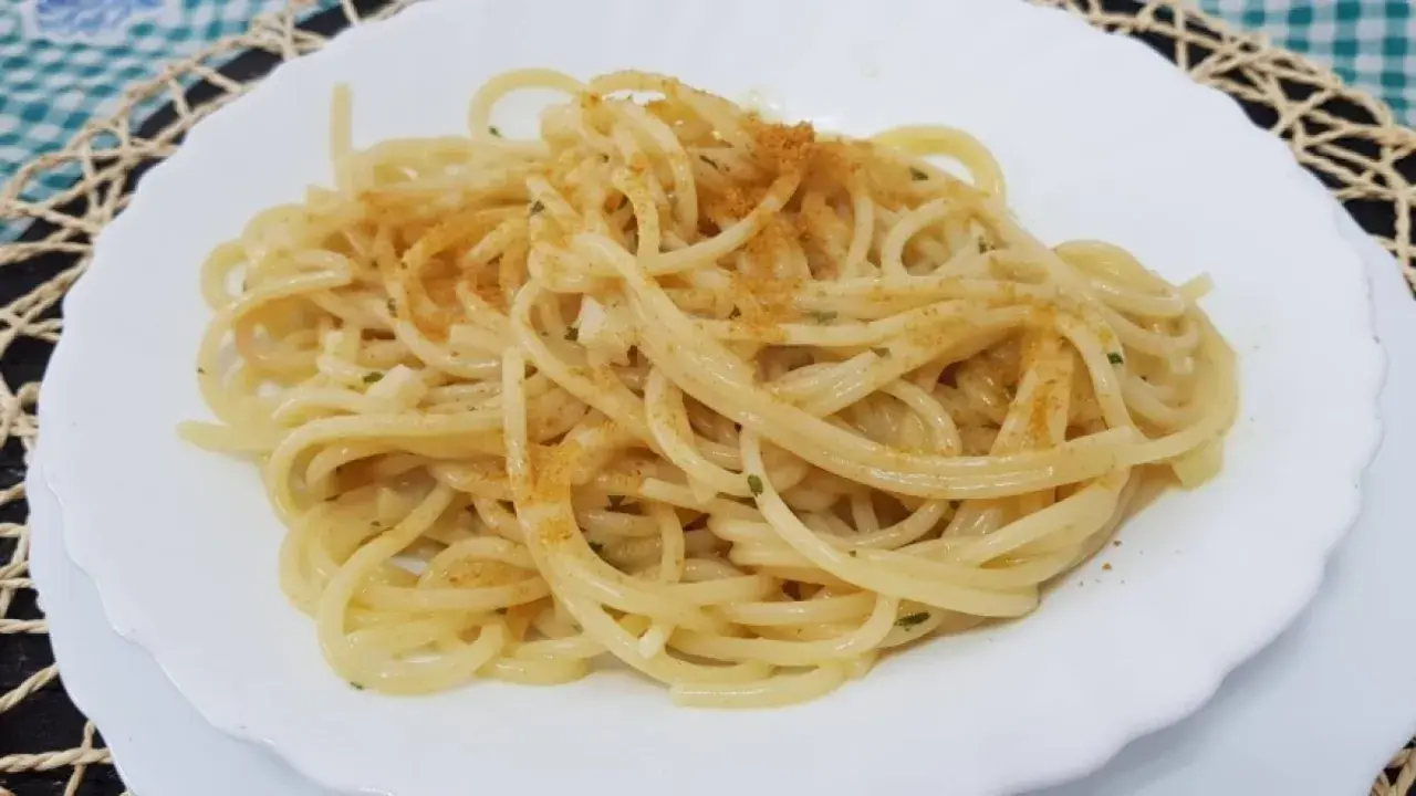 Spaghetti conditi con un filo d'olio, aglio e prezzemolo, spolverati con la preziosa bottarga.