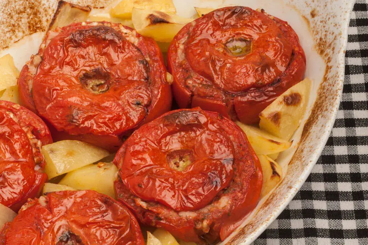 Pomodori ripieni di riso e patate al forno, un piatto saporito e colorato.