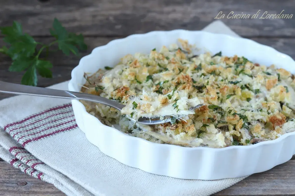 Un invitante tortino di alici gratinato, con croccante pangrattato e prezzemolo fresco, pronto per essere gustato.