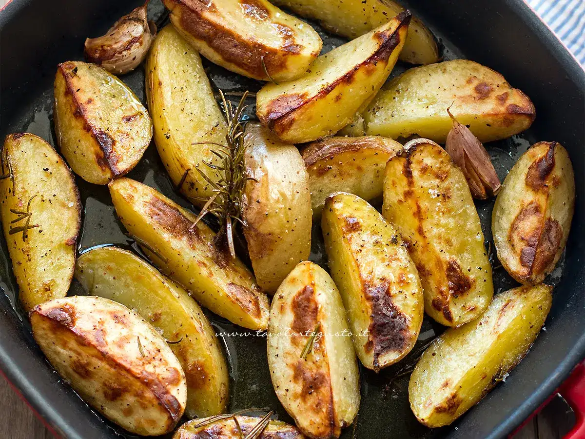 Patate con la buccia dorate al forno, condite con rosmarino e aglio. Un contorno rustico e saporito.